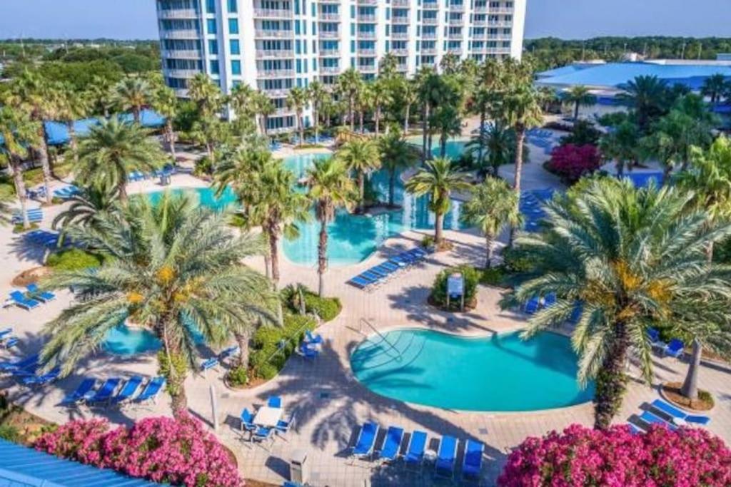 德斯坦5 Star Resort 2BR 2 BATH King Suite Shuttle Pools Across from Beach的享有棕榈树和游泳池度假村的空中景致