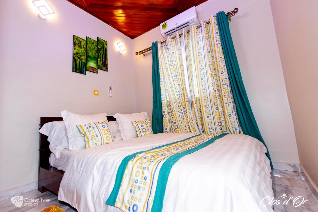 杜阿拉Clos d'Or, Appartements meublés Douala Makepé的一间带床的卧室,位于带窗户的房间内