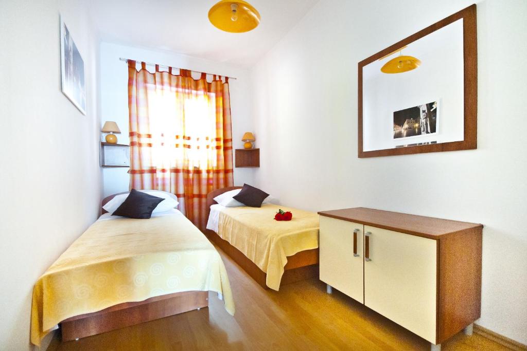 杜布罗夫尼克一流美景公寓的一间卧室设有两张床、一个橱柜和一个窗口。