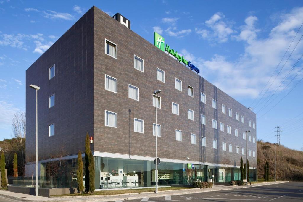 姆提瓦巴哈潘普洛纳快捷假日酒店的一座大型砖砌建筑,上面有绿色标志