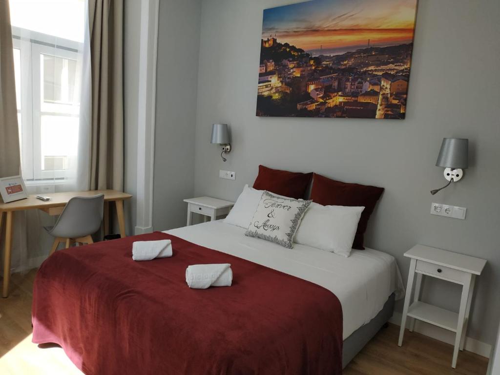 里斯本法克罗斯3号旅馆的一间卧室配有一张带红色毯子的床