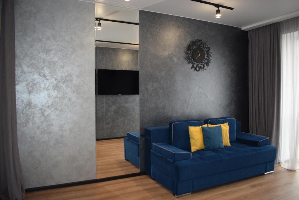 卢茨克Дизайнерські апартаменти в ЖК DreamTown 10б的客厅里配有带黄色枕头的蓝色沙发