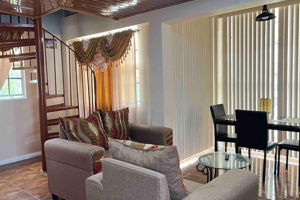 乔治敦Odyssey Suites Loft Apartment的客厅配有沙发和桌子