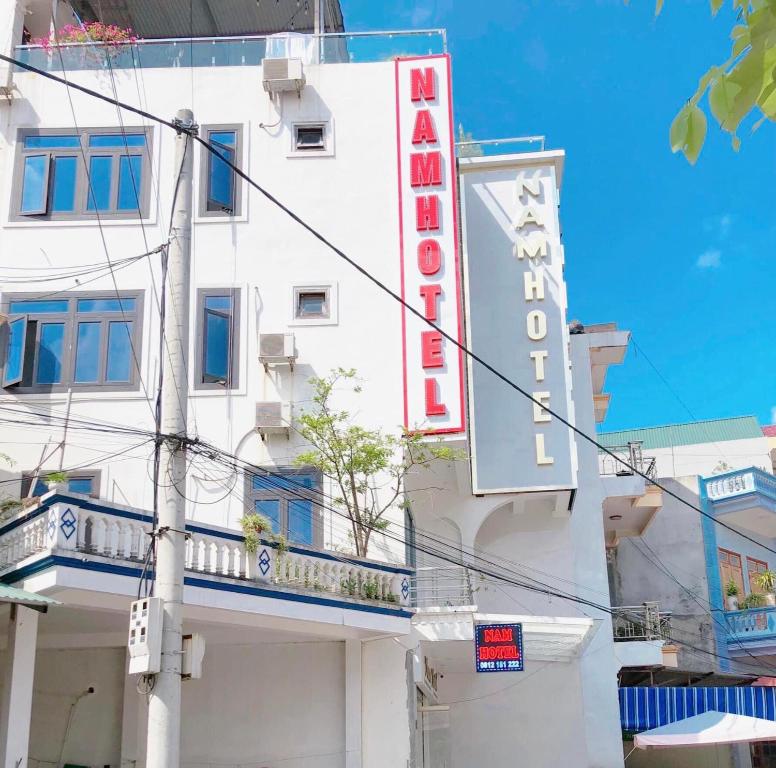 Bản CoKhach san Nam Hotel的一座白色的建筑,上面标有酒店标志