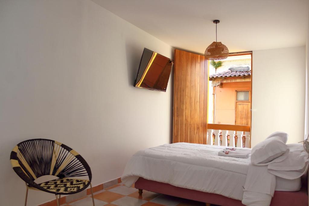 卡塔赫纳Hostal Casa Torres Centro Historico - Adults Only的卧室配有床、椅子和窗户。
