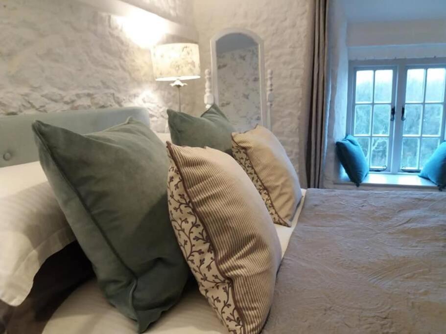 WhitwellThe Bake House (Berryl Farm Cottages)的卧室配有带枕头的床铺和窗户。