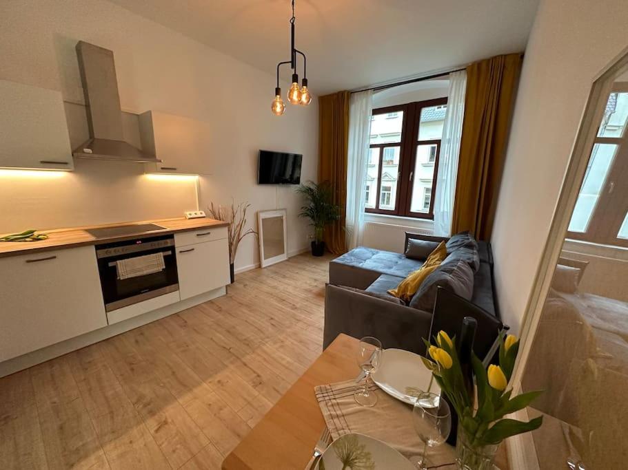 阿尔滕堡Herrliches wohnen mit Teichblick的带沙发和桌子的客厅以及厨房。