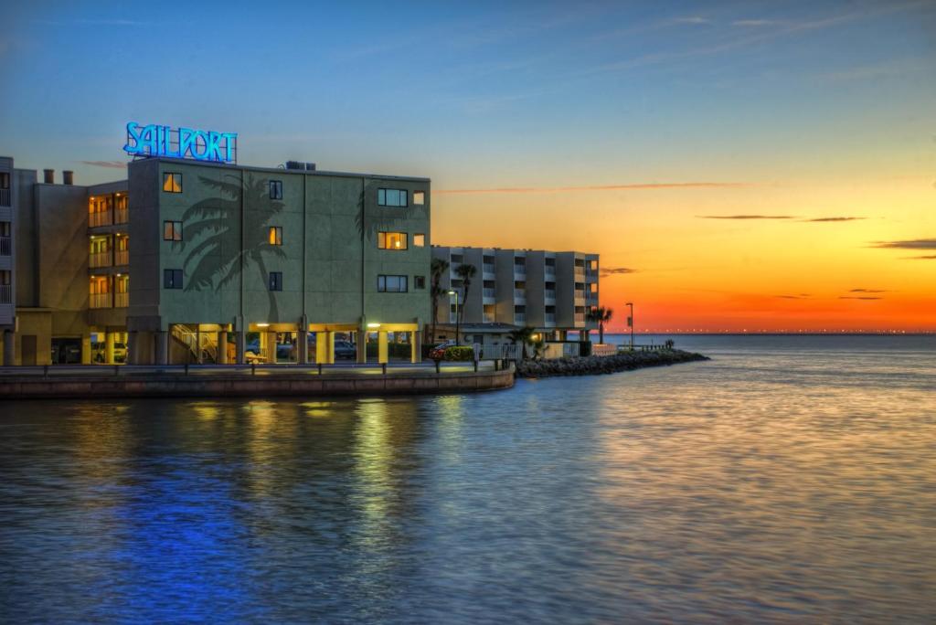 坦帕赛博特海滨套房酒店的水面上的建筑,背景是日落