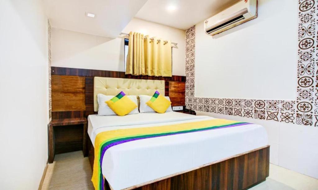 孟买KALPANA RESIDENCY - Near US Embassy的一间卧室配有一张大床和色彩缤纷的毯子