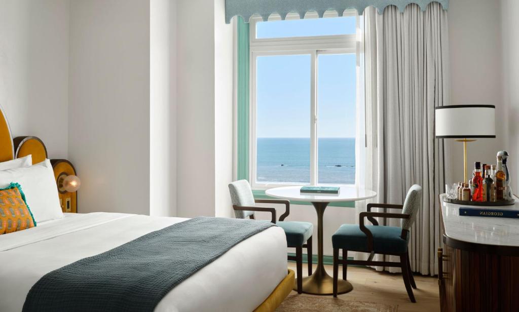 洛杉矶乔治亚酒店的酒店客房设有床、桌子和窗户。