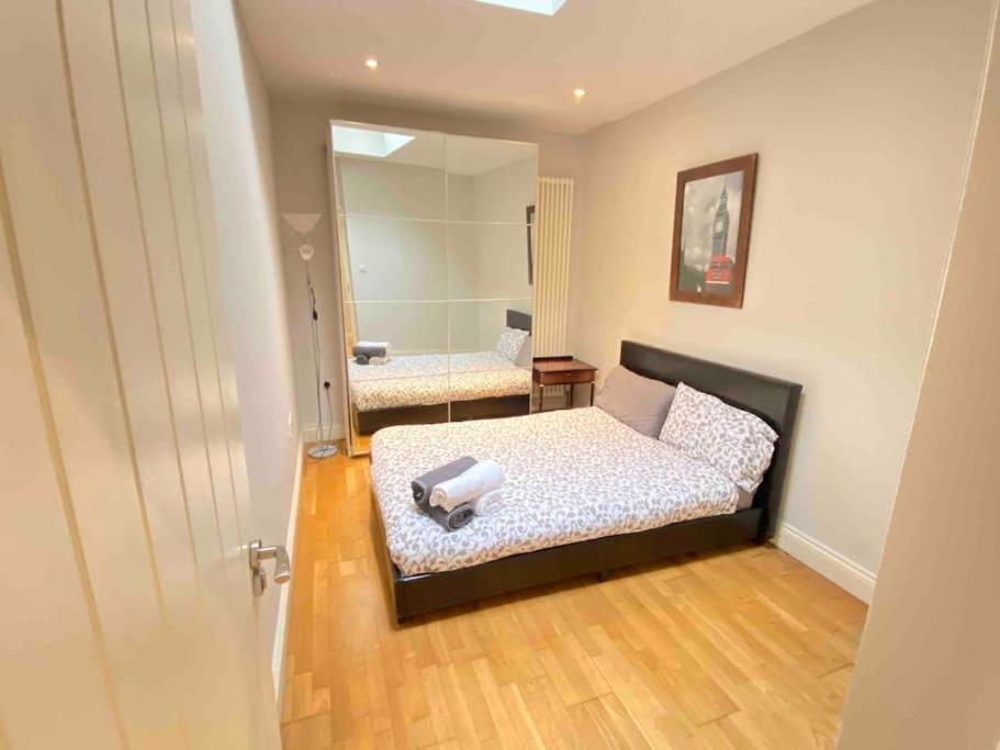 伦敦Spacious 3 bedrooms in Edgwar road的一间卧室配有一张床和一面大镜子