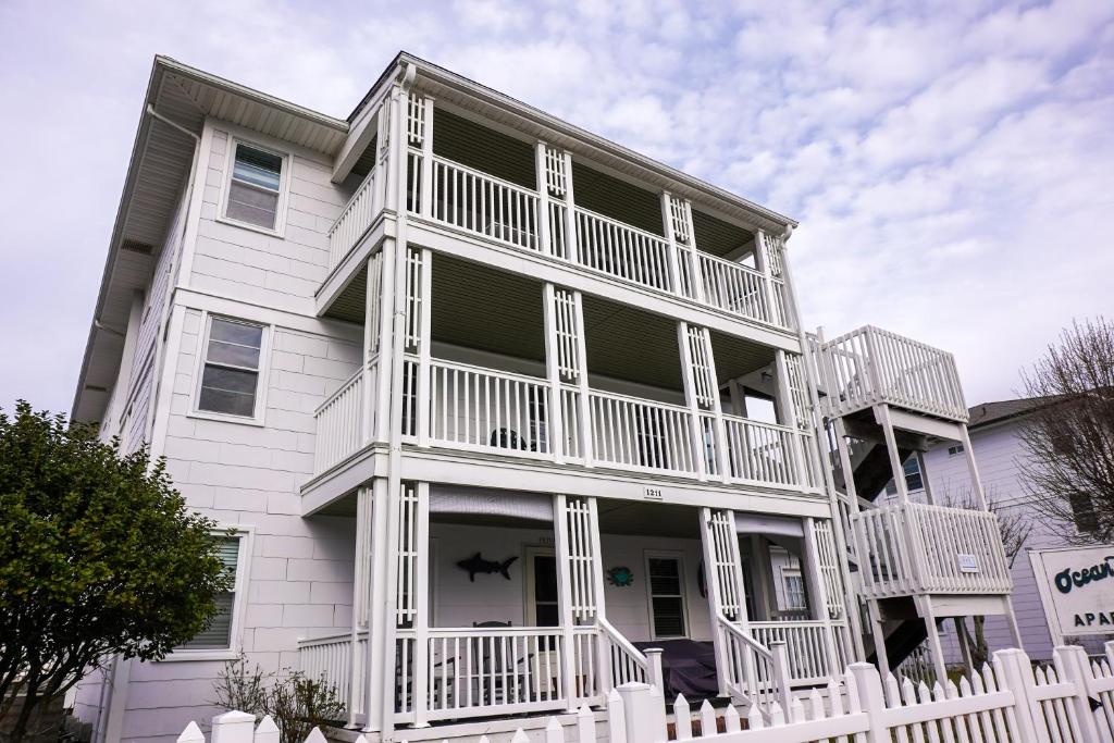 大洋城Ocean Terrace Family Apartments的前面有白色围栏的白色房子