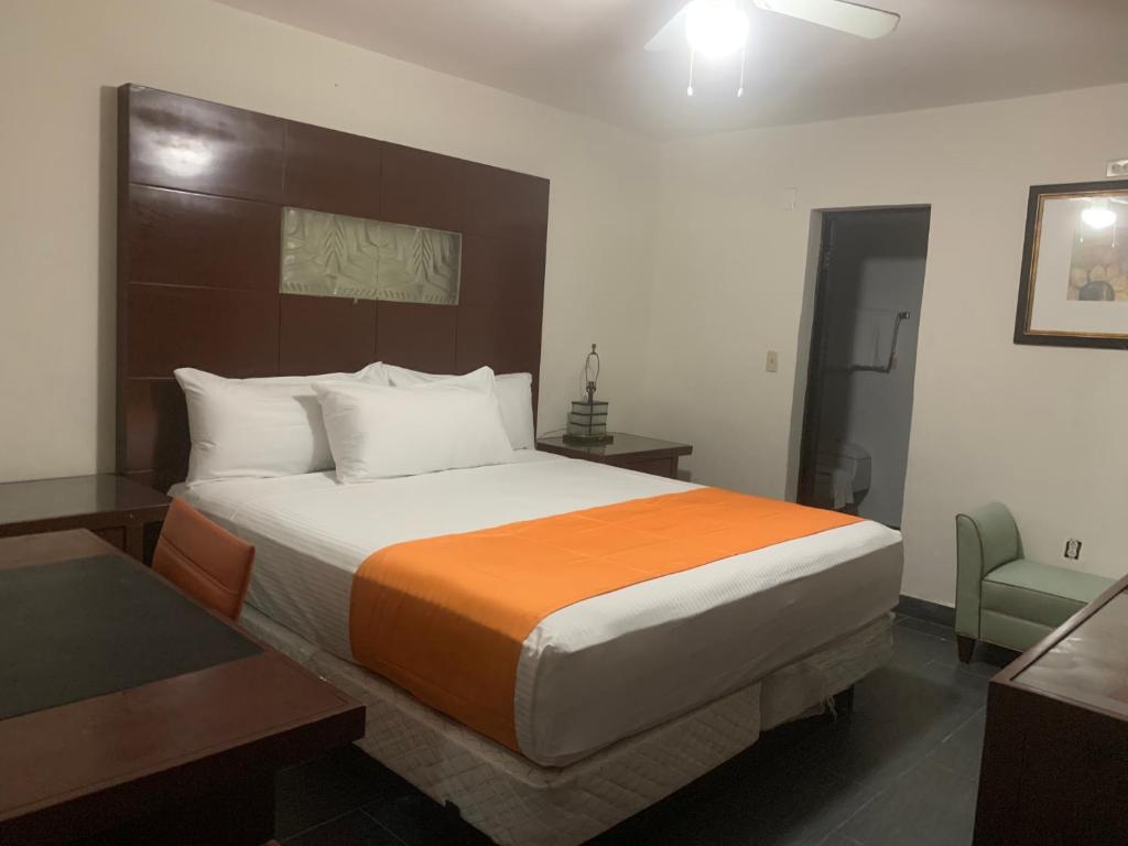 墨西卡利HOTEL DORADO DIAMANTE的一间卧室配有一张带橙色毯子的大床