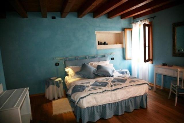 Brendola拉奎特住宿加早餐酒店的一间设有一张蓝色墙壁床铺的卧室