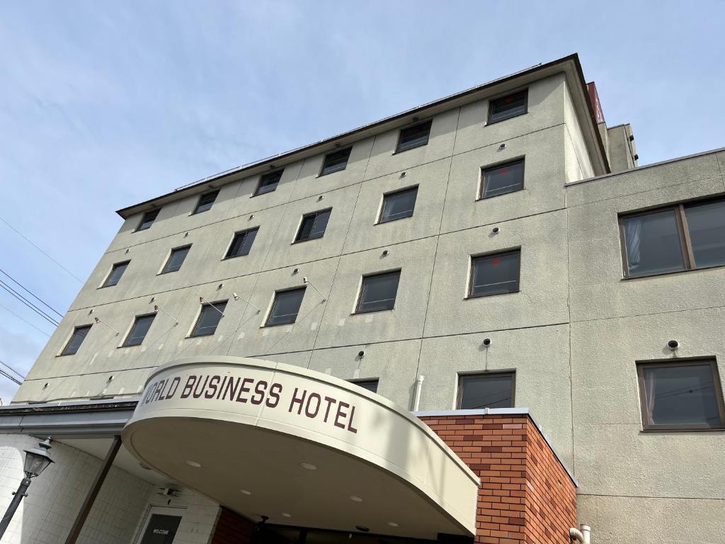 饭田市World Business Hotel的一座建筑,上面有读新商务酒店的标志