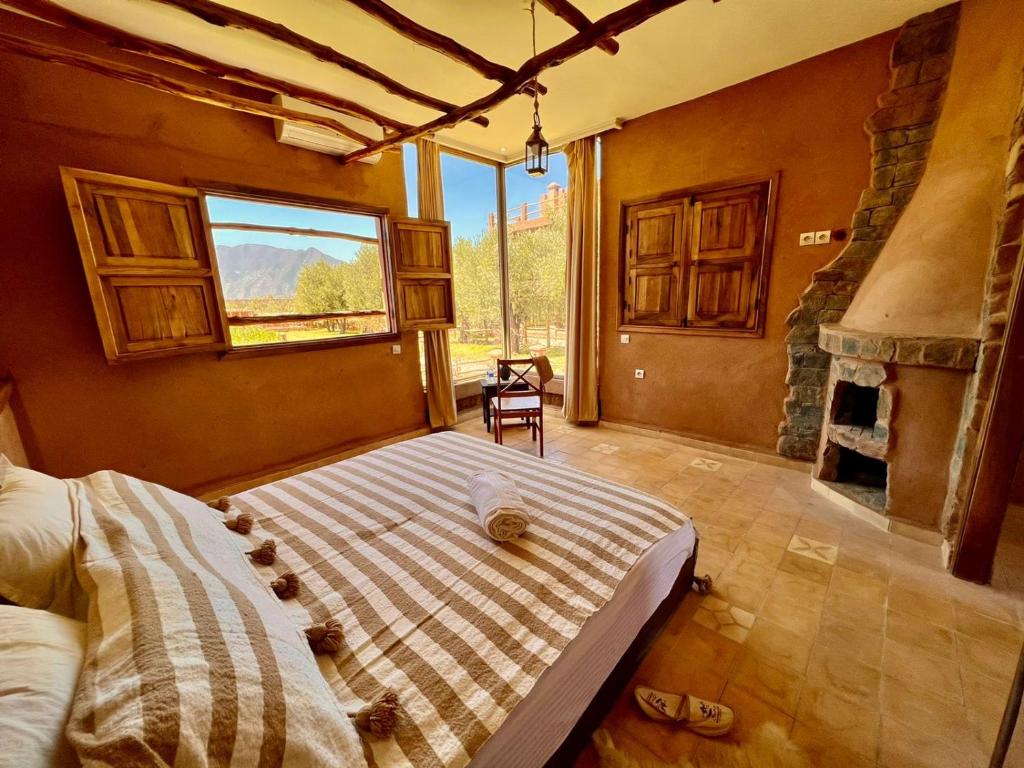奥伊俄贞Bin Jbal Resort的带壁炉的客房内的一间卧室配有一张床