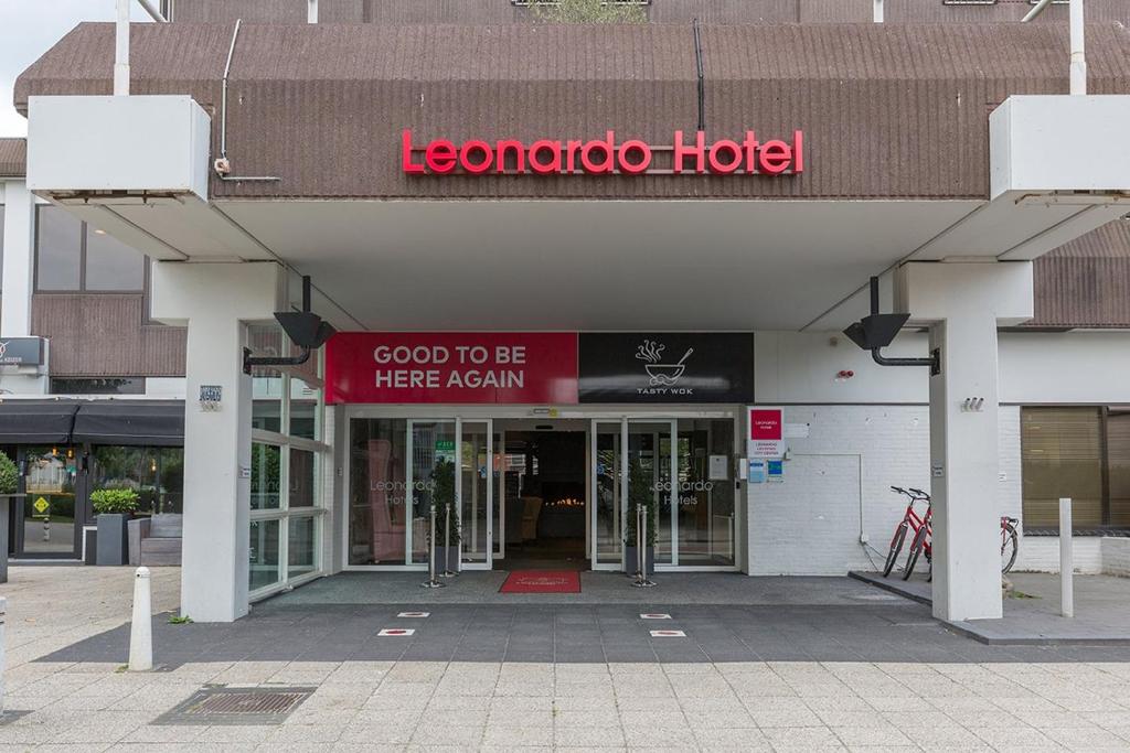 莱利斯塔德Leonardo Hotel Lelystad City Center的大楼前有红色标志的酒店