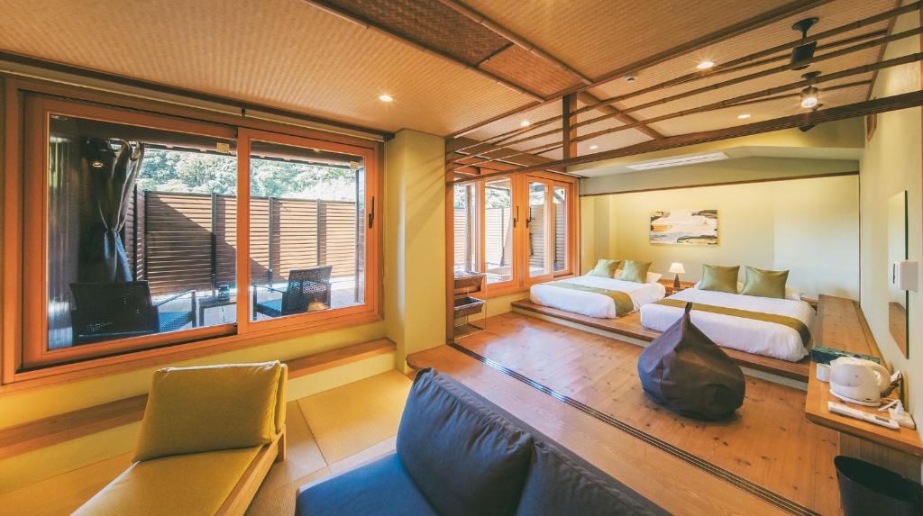 GotsuOWL RESORT ARIFUKU ONSEN的一间卧室设有两张床、一张沙发和一个窗口