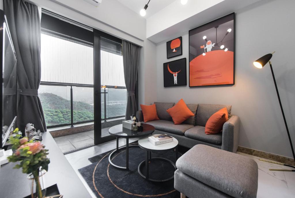 深圳WSSU 微宿精品公寓-深圳大学城塘朗地铁站店的客厅配有沙发和桌子
