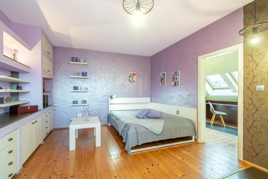 普罗夫迪夫Zen Home pLOVEdiv的卧室设有紫色墙壁、一张床和一张桌子