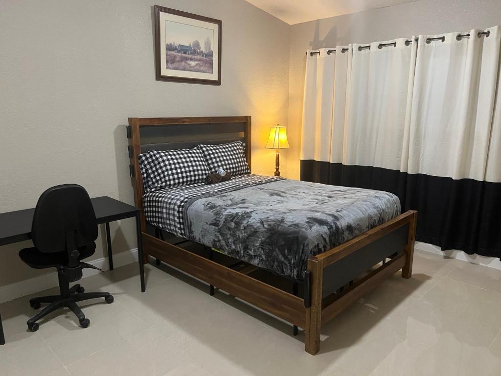 坦帕Oak Ridge House的一间卧室配有一张床、一张桌子和一把椅子