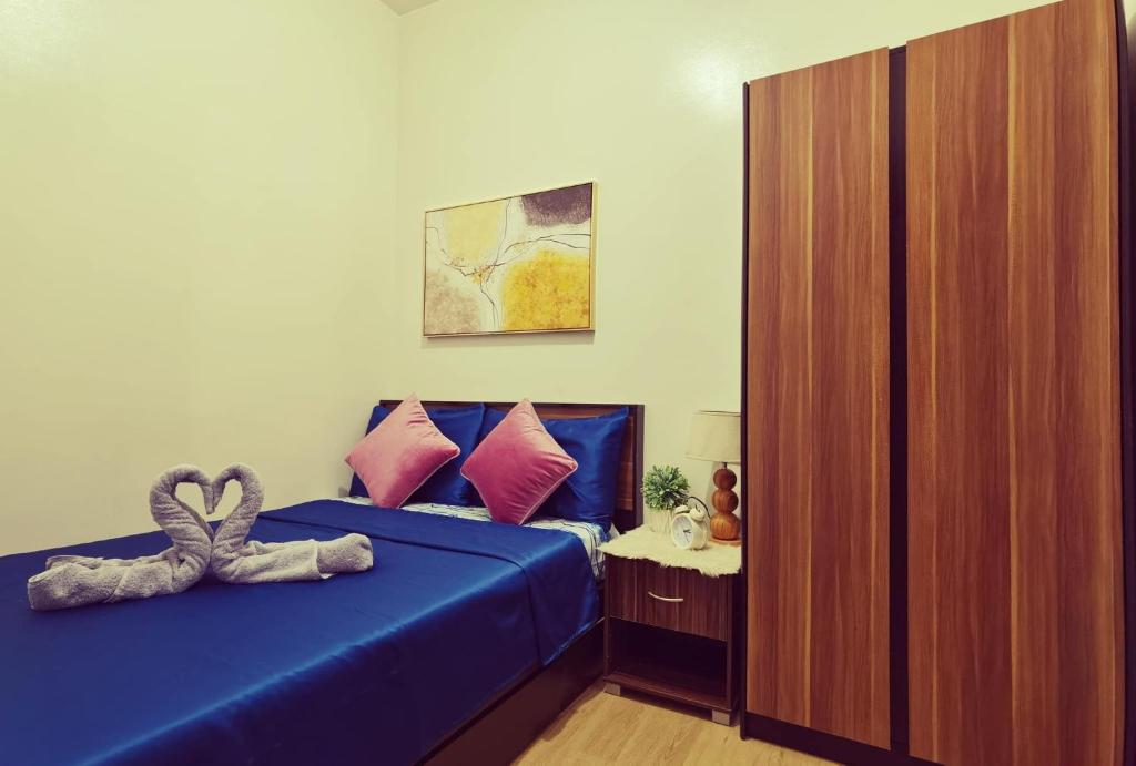 马尼拉Condominium at Spring Residences near Airport的一间卧室配有一张蓝色的床和心枕