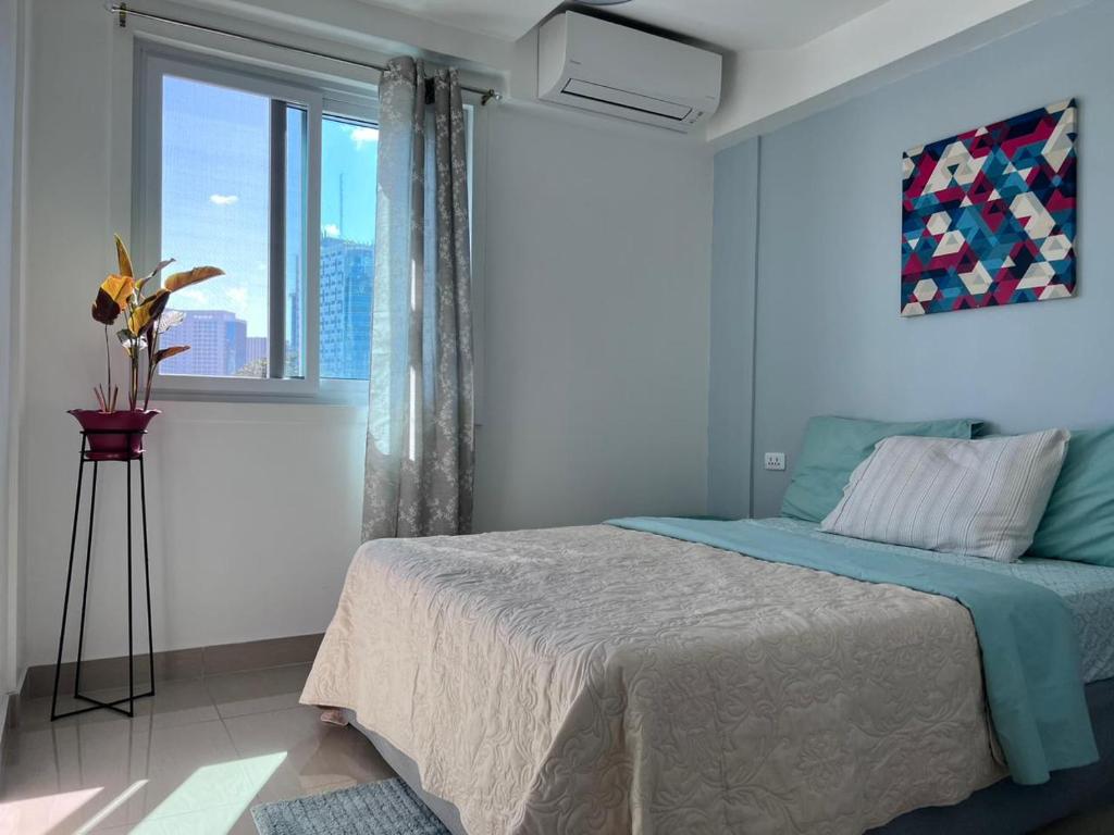 宿务Cebu Mini Hotel的一间卧室设有一张床和一个大窗户