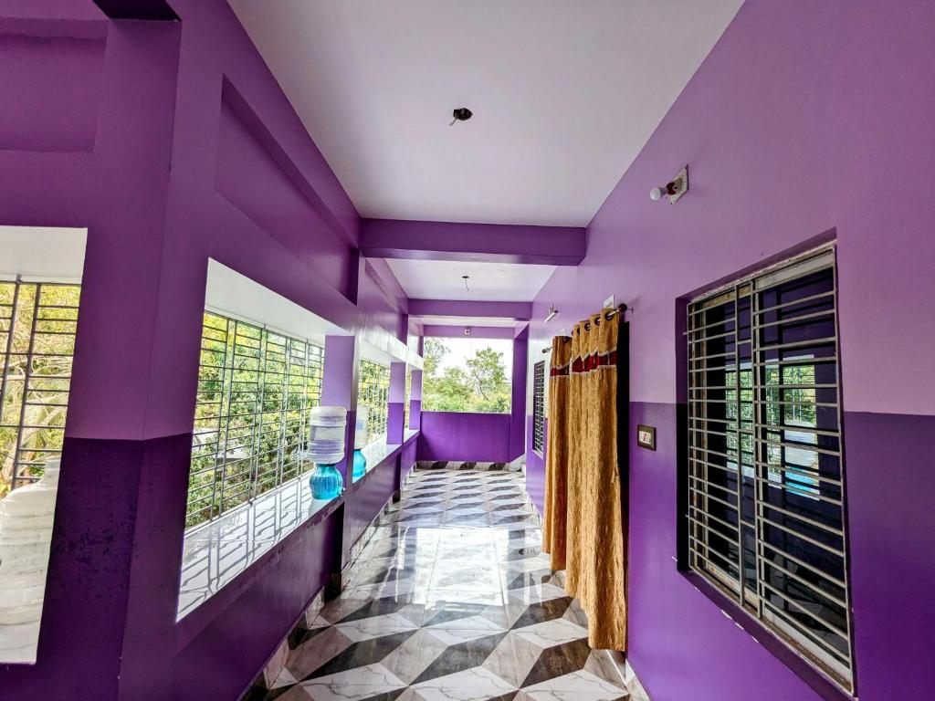 PurbbadulkiSundarban Tulip Homestay, Pakhiralay, WB的一间拥有紫色墙壁的客房和一个带窗户的走廊