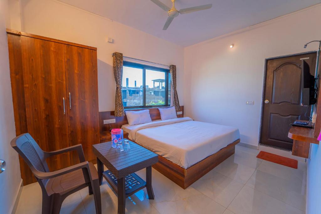 马哈巴莱斯赫瓦尔Dhimahi Residency的一间卧室配有一张床和一张桌子及椅子