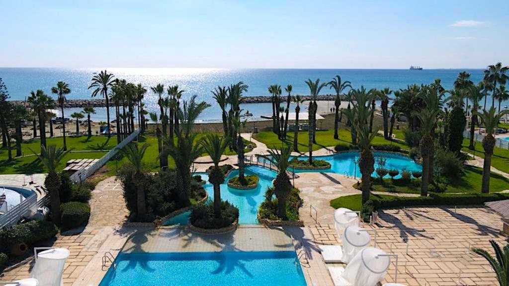 拉纳卡Sandy Beach Hotel & Spa - ex Sentido的享有带游泳池和海洋的度假村的空中景致