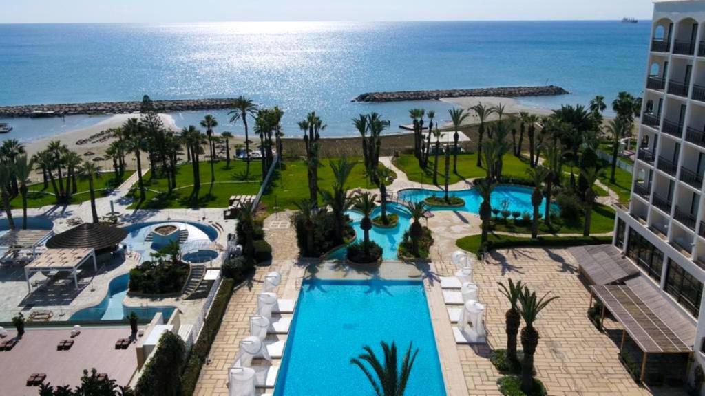 拉纳卡Sandy Beach Hotel & Spa - ex Sentido的享有带游泳池和海洋的度假村的空中景致