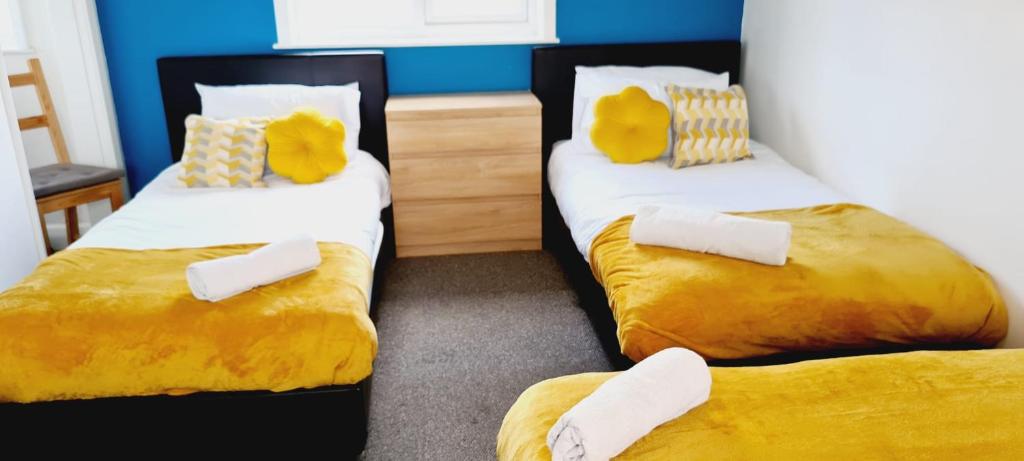德比Browning House Bedrooms I Long or Short Stay I Special Rate Available的配有两张黄色和白色床单的床铺