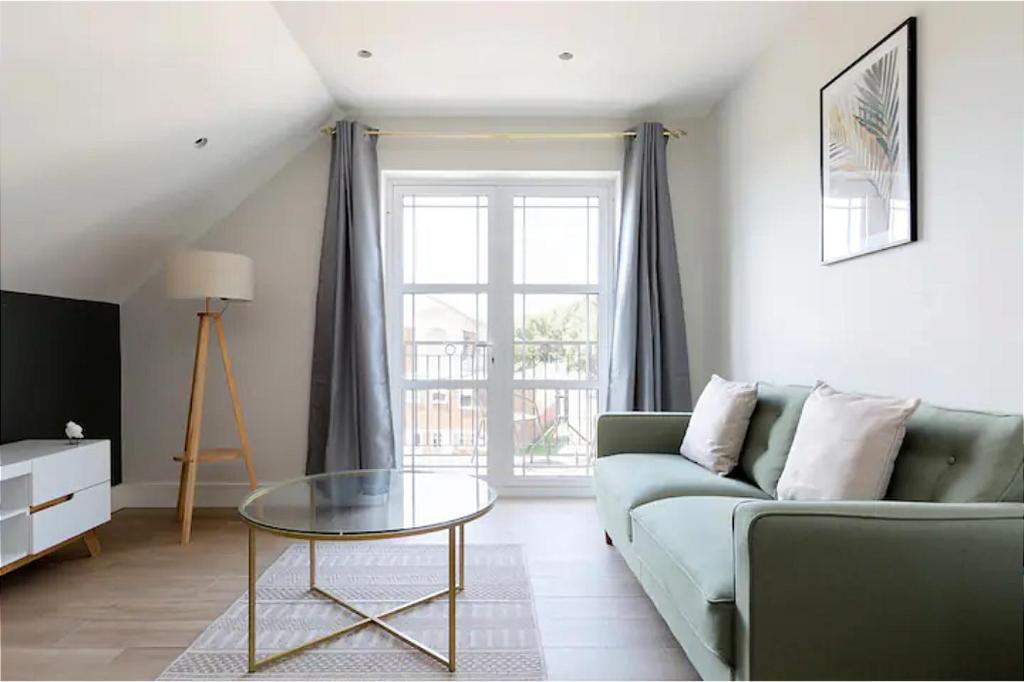 亨顿The Finchley Apartment的带沙发和玻璃桌的客厅