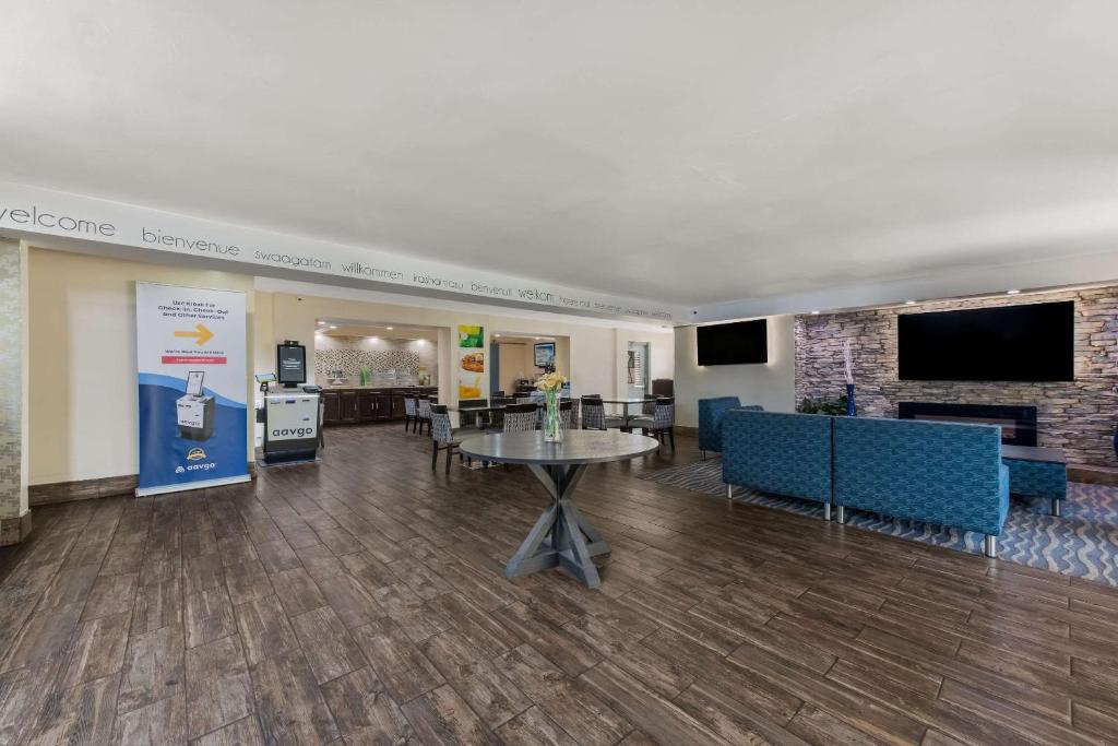 夏洛特夏洛特机场品质套房酒店的大堂设有桌椅和电视。