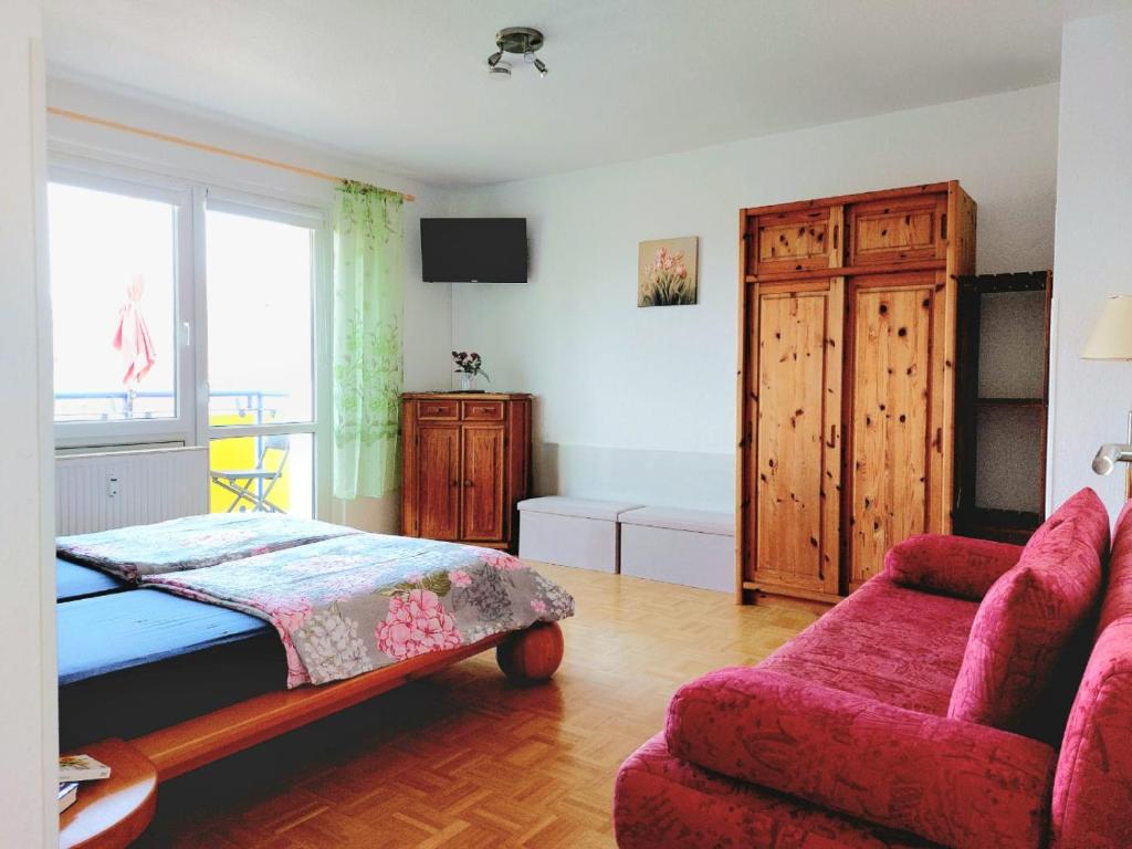 德累斯顿Helles Apartment mit Balkon am Großen Garten nahe Stadtzentrum的一间卧室配有一张床、一张沙发和一个窗口