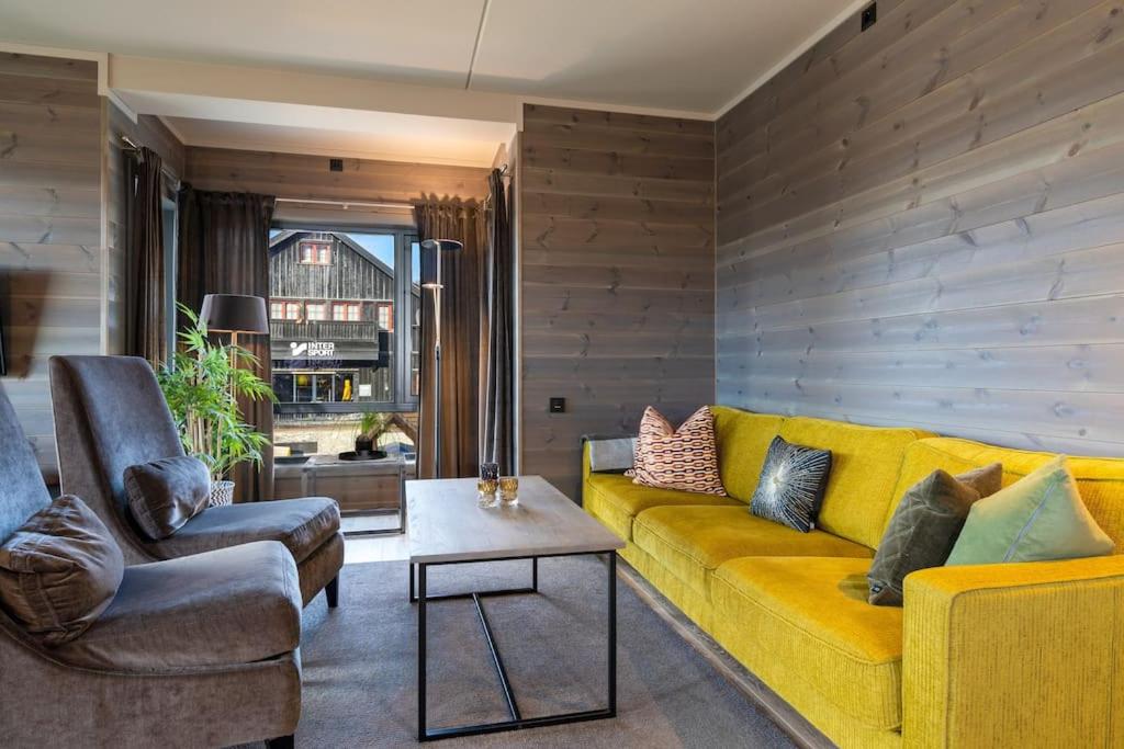 贝特斯托尔Tiltalende og romslig leilighet的客厅配有黄色沙发和两把椅子