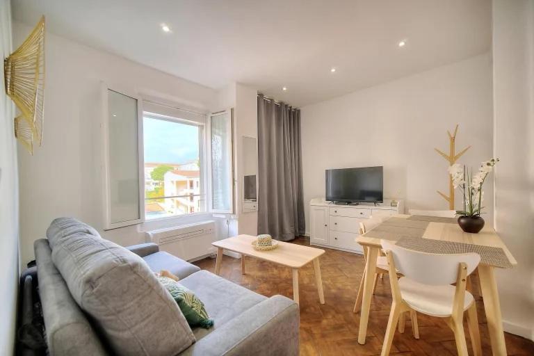 戛纳LOENA CANNES CENTRE - Appartement rénové 2 pièces - 4 personnes - proche croisette palais festival plage - internet gratuit - climatisation - non fumeur的客厅配有沙发和桌子