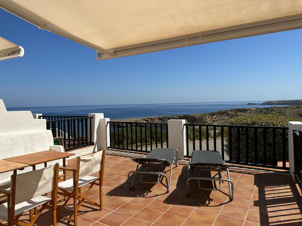 桑帕克ALDEAMAR F1 by SOM Menorca的一个带桌椅的庭院和大海