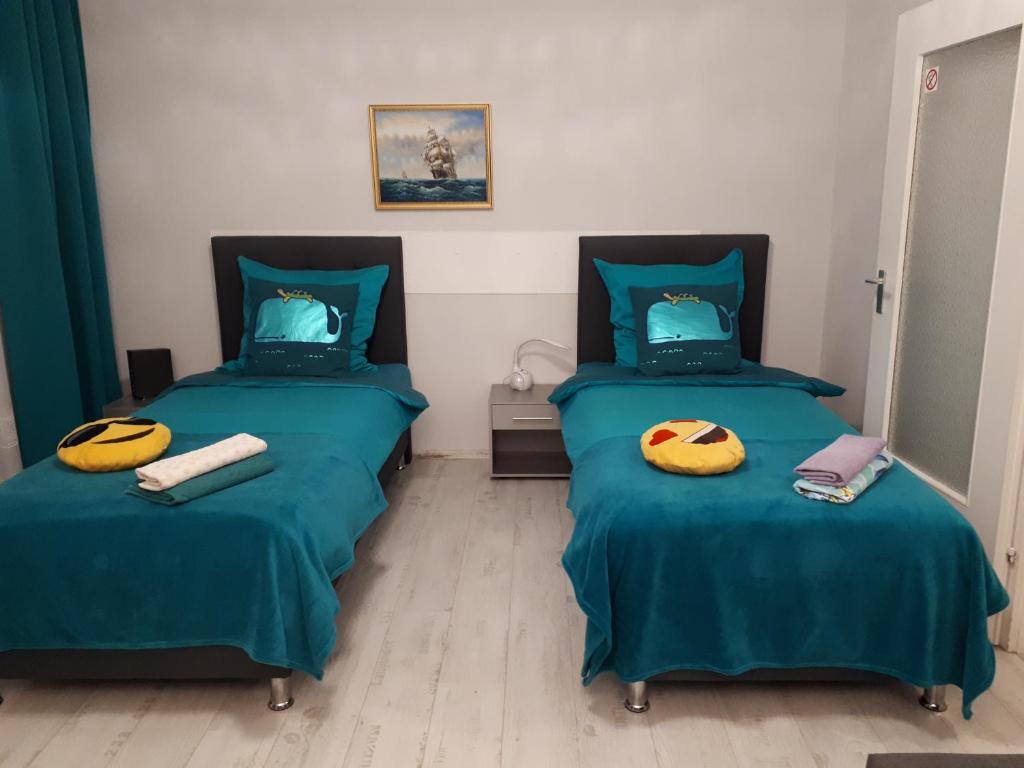 汉诺威Comfort的配有绿床单和黄色枕头的客房内的两张床