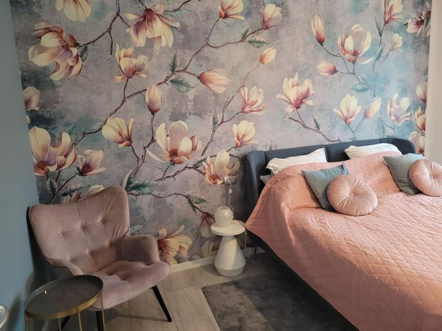 多马索Lago-apartment Midy, sfeervol, zwembad, airco的一间卧室设有一张床和花卉墙