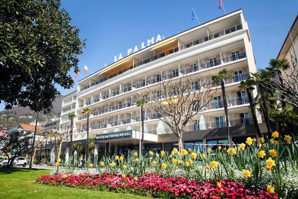 洛迦诺帕尔马奥拉克酒店的一座大建筑前面有鲜花