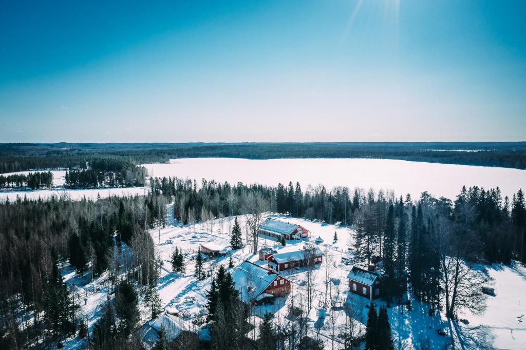 艾赫泰里沃尔克森洛马酒店的湖旁雪地中房屋的空中景观