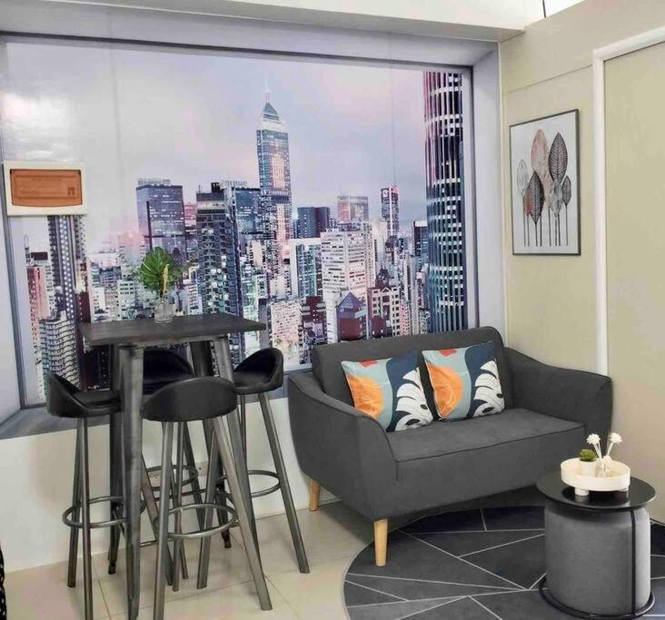 马尼拉Chic 2BR Condo Unit at South Residences的带沙发的客厅,享有城市美景
