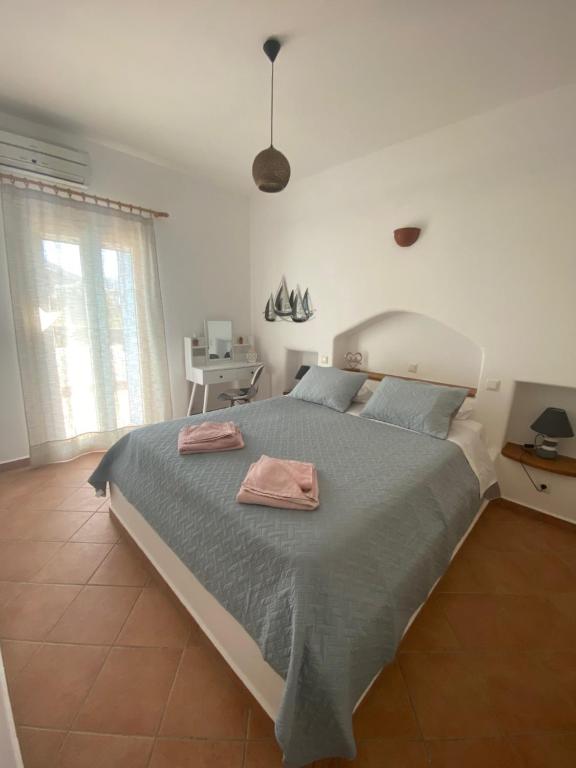 纳乌萨Nikos Country House的一间卧室配有一张大床和两条毛巾