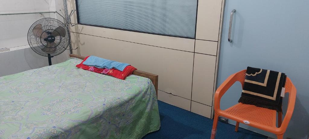 达卡Kompass Homestay - Affordable AC Room With Shared Bathroom in Naya Paltan Free WIFI的一间小卧室,配有一张床和一把椅子