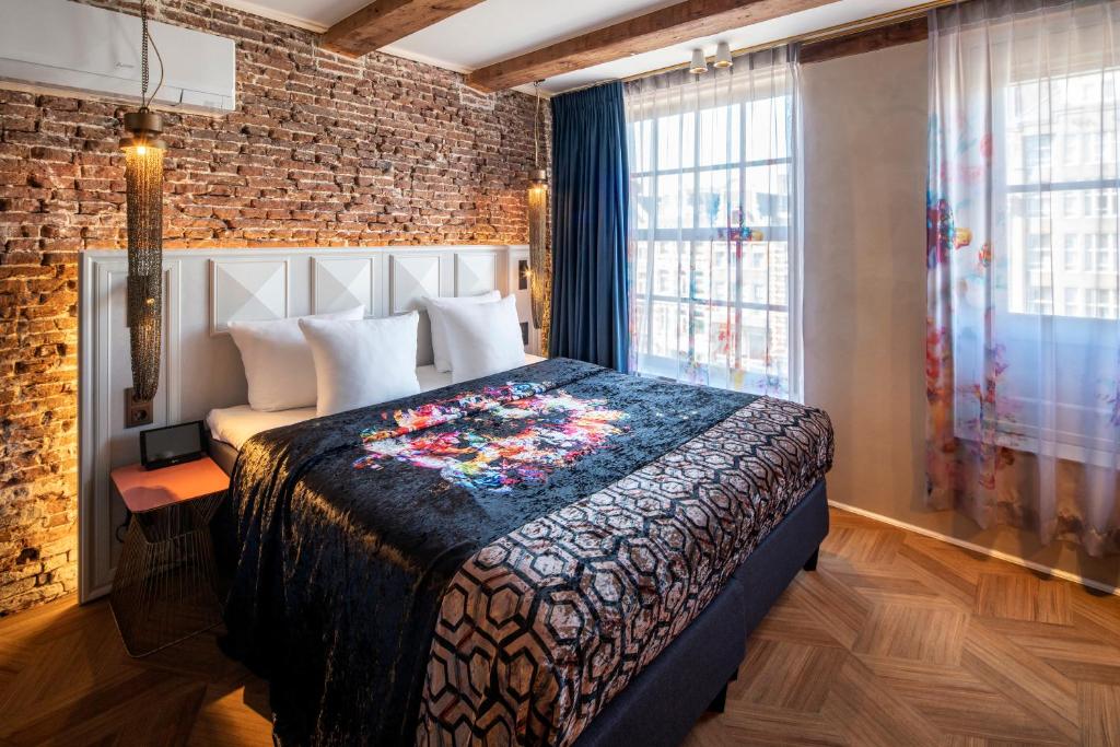 阿姆斯特丹Mister Highland Hotel的一间卧室设有一张床和砖墙
