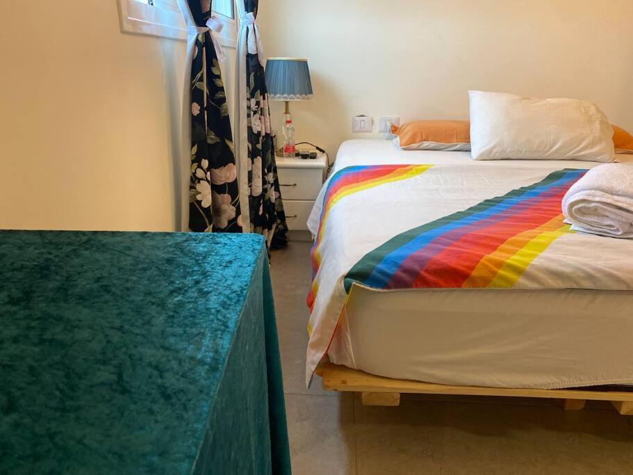 YehudSarin room的一间卧室配有一张带彩虹毯子的床