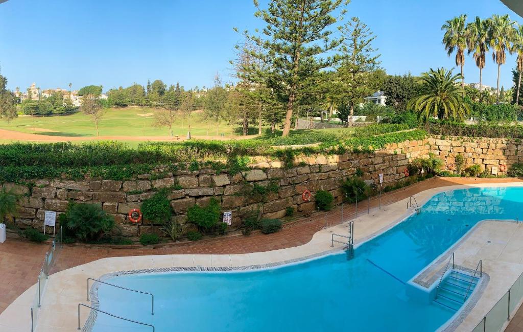 米哈斯科斯塔Dream Apartment in Mijas Golf Limonar的一座大型游泳池,毗邻石墙