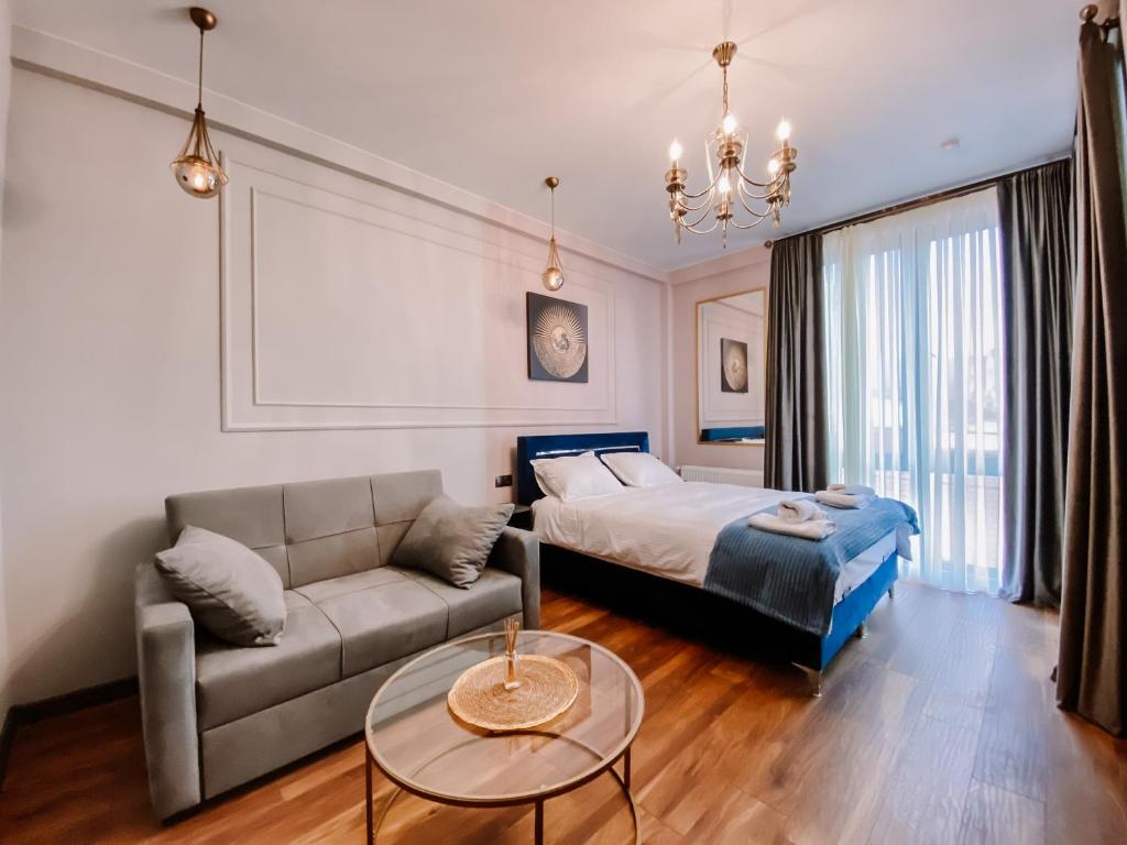 第比利斯Trinity Hotel的一间卧室配有一张床、一张沙发和一张桌子