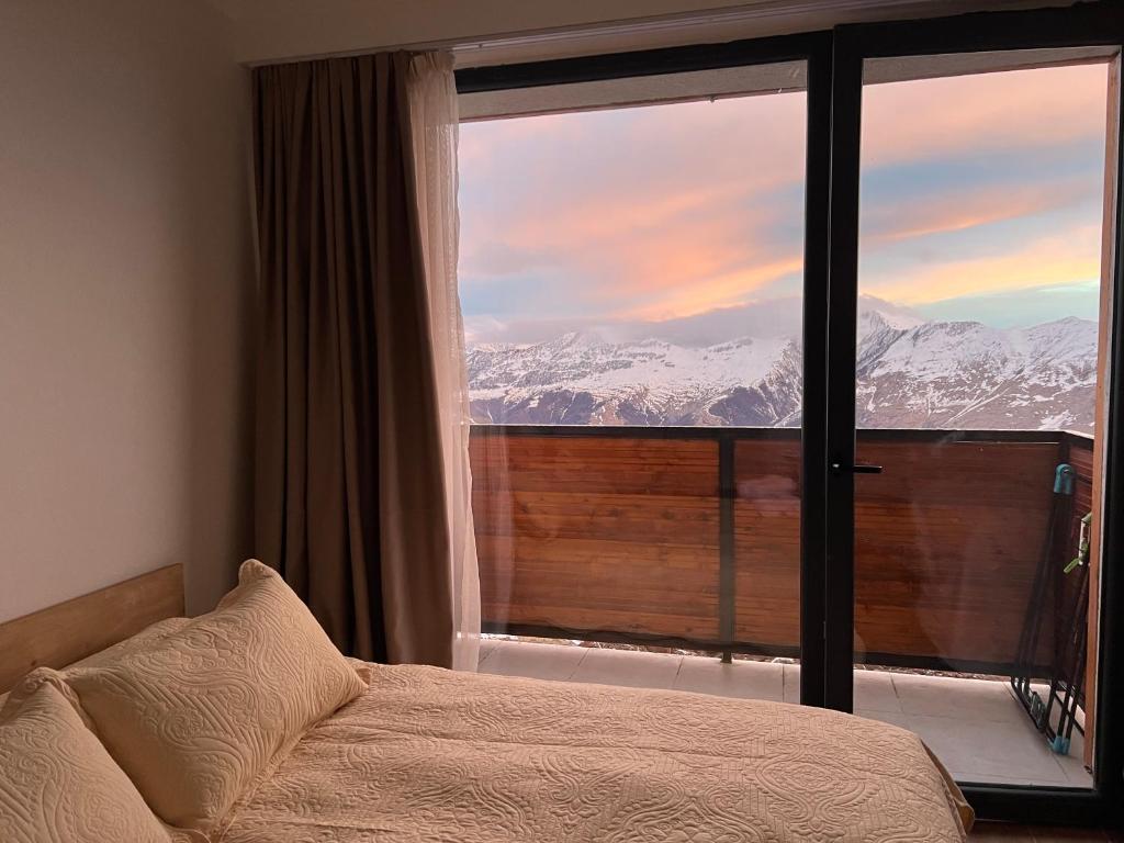 古多里Twins #144 New Gudauri with Mountain View的一间卧室设有一张床和一个拥有雪覆盖山脉的大窗户